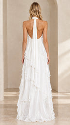 Back view of woman showcasing the open back and tie halter detail of the white maxi gown