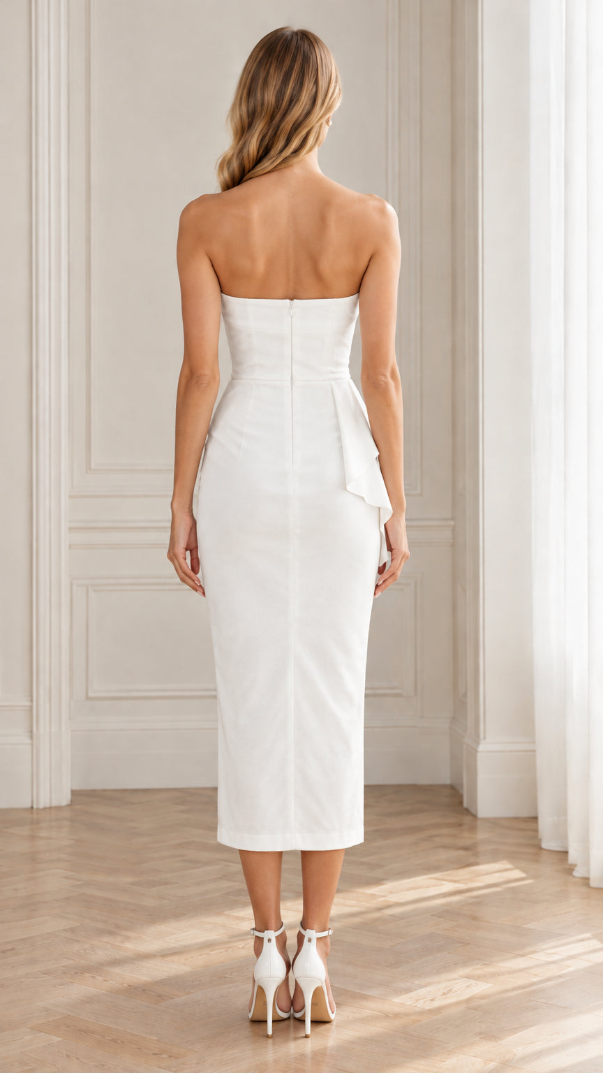 Back view of model wearing white strapless sheath midi dress with zipper closure