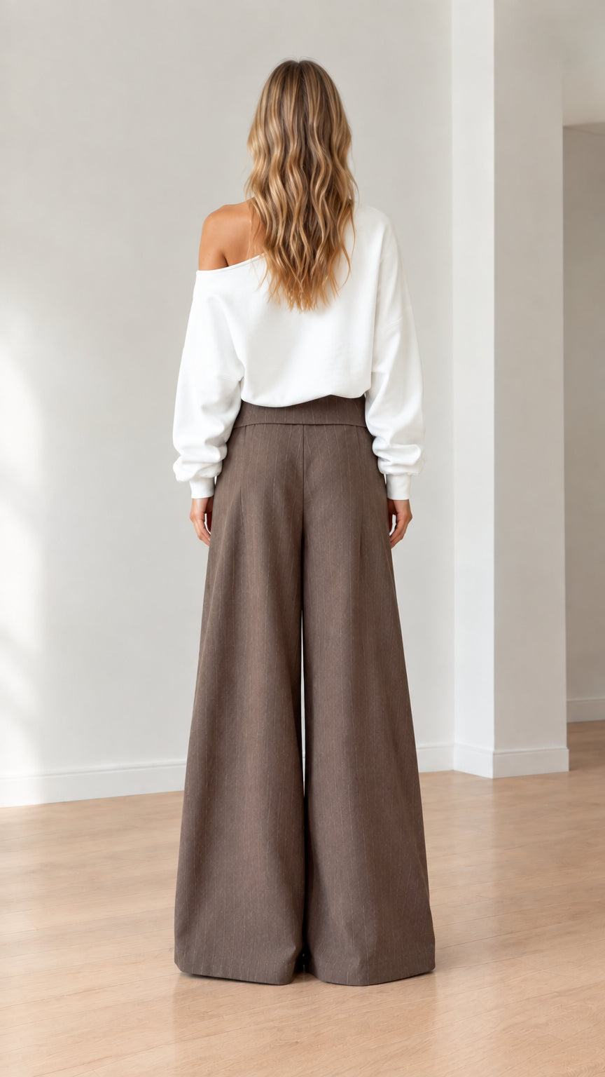 Back view of model in white off-shoulder sweatshirt and brown wide-leg pants