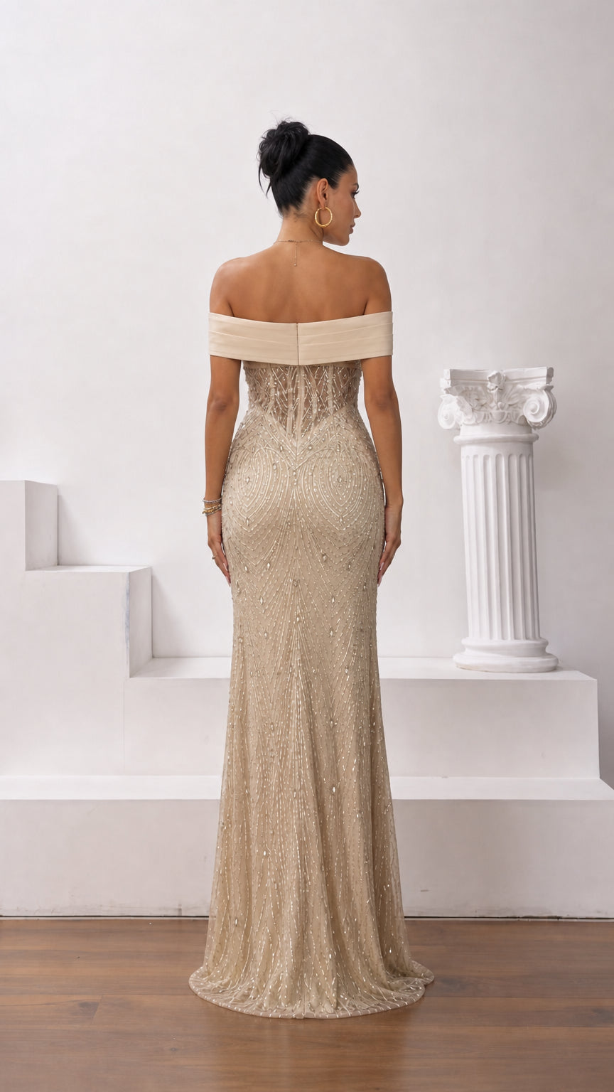 Back view of champagne gold off-the-shoulder beaded evening gown showing sleek fit