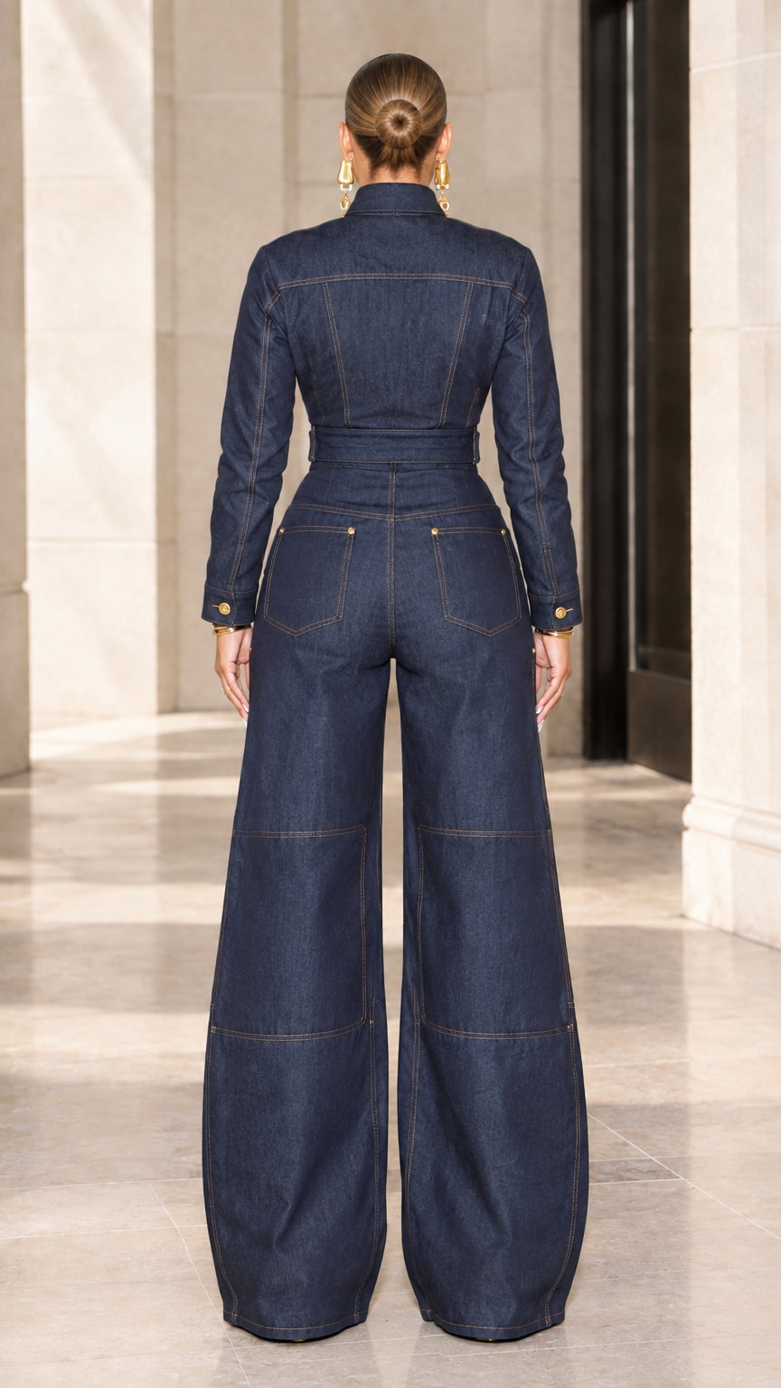Back view of dark blue wide leg denim jumpsuit showing rear pockets and tailored waist
