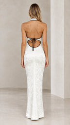 Back view of model showing open back and tie detail of the white jacquard maxi dress