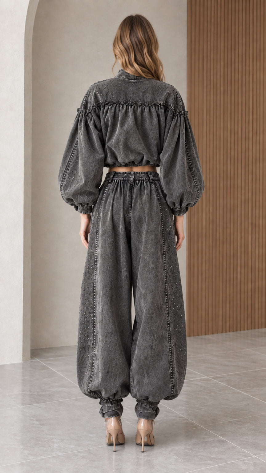Back view of model highlighting the blouson back construction and high-rise elasticized denim trousers
