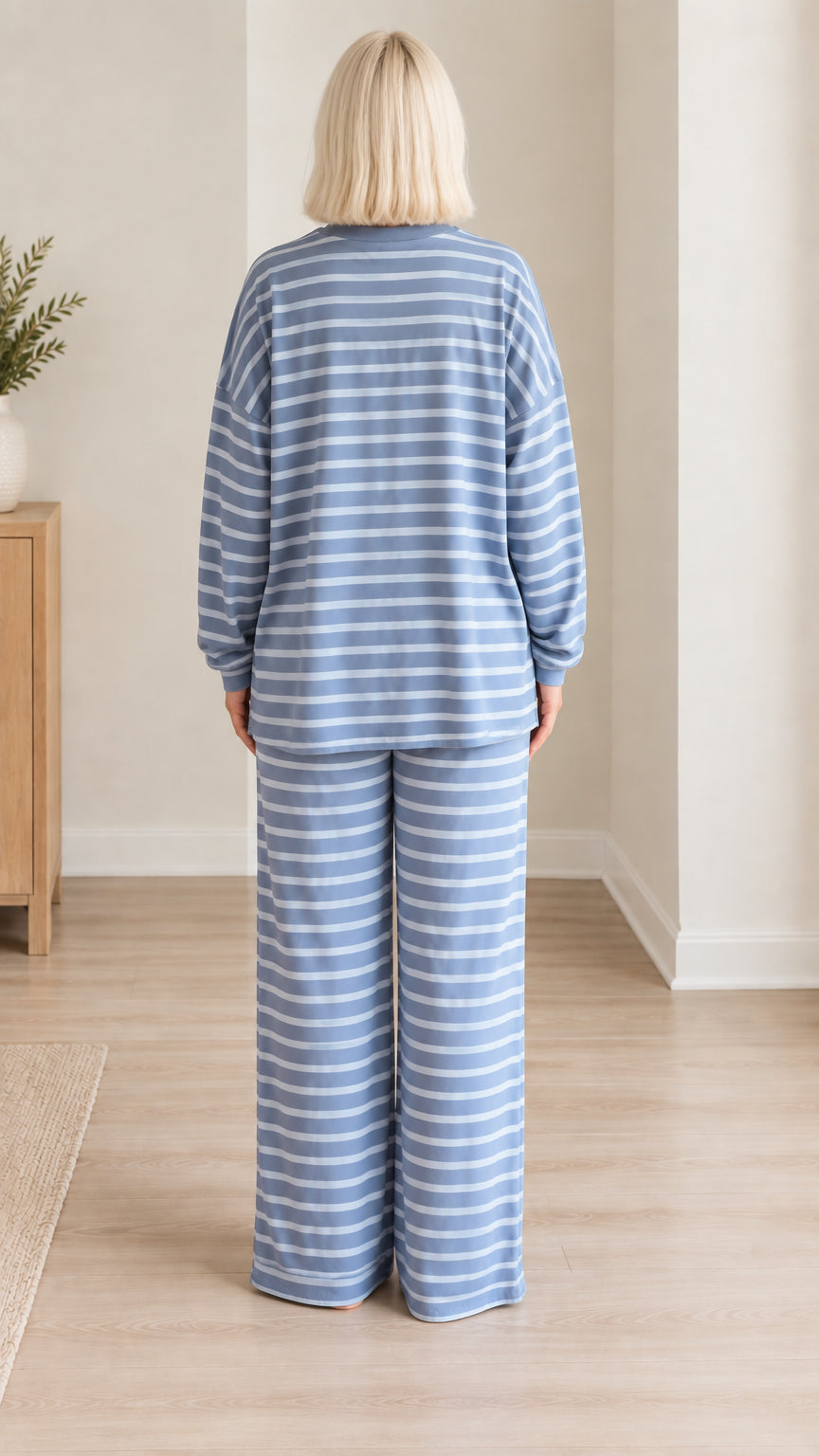 Back view of woman wearing blue striped pajama set with wide leg trousers