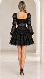 Back view of model showing square back and tiered skirt of black tulle mini dress