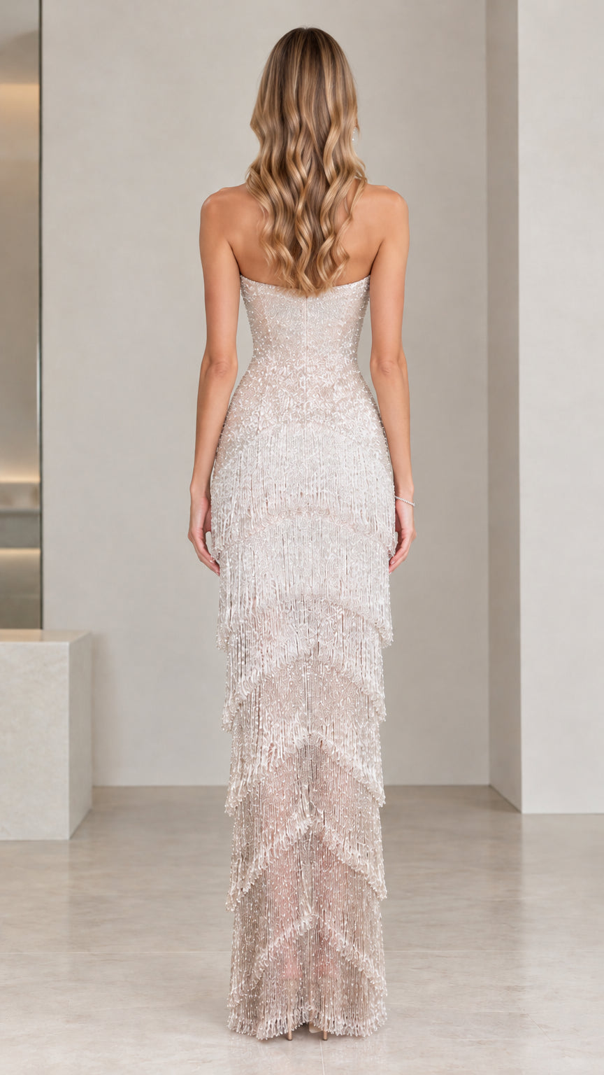Back full-length view of champagne strapless beaded fringe tiered gown