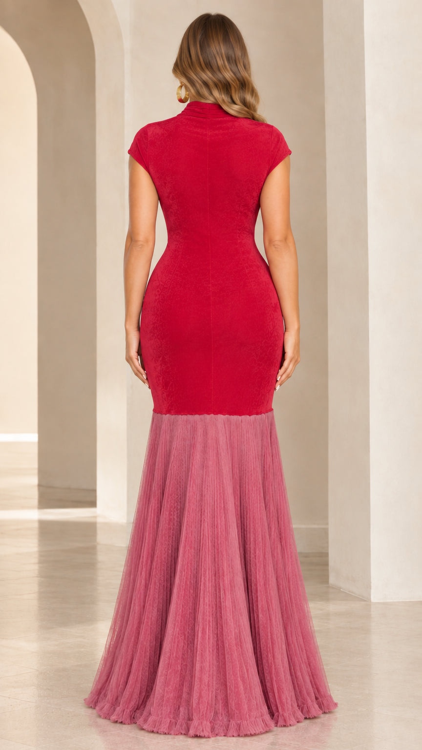 Back view of woman wearing red and rose mermaid dress showing high back zip closure and flared hem