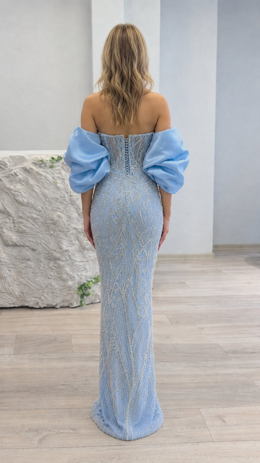 Back view of light blue beaded gown showing lace-up corset and dramatic puff sleeves