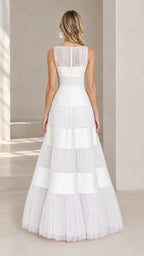Back view of model wearing white sleeveless evening gown showing sheer illusion back