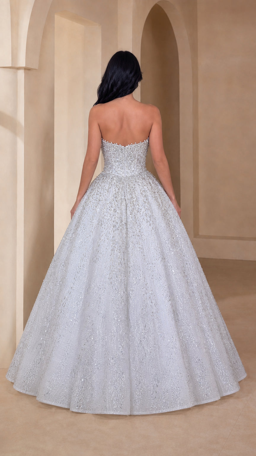 Back view of model in silver white strapless floor-length ball gown