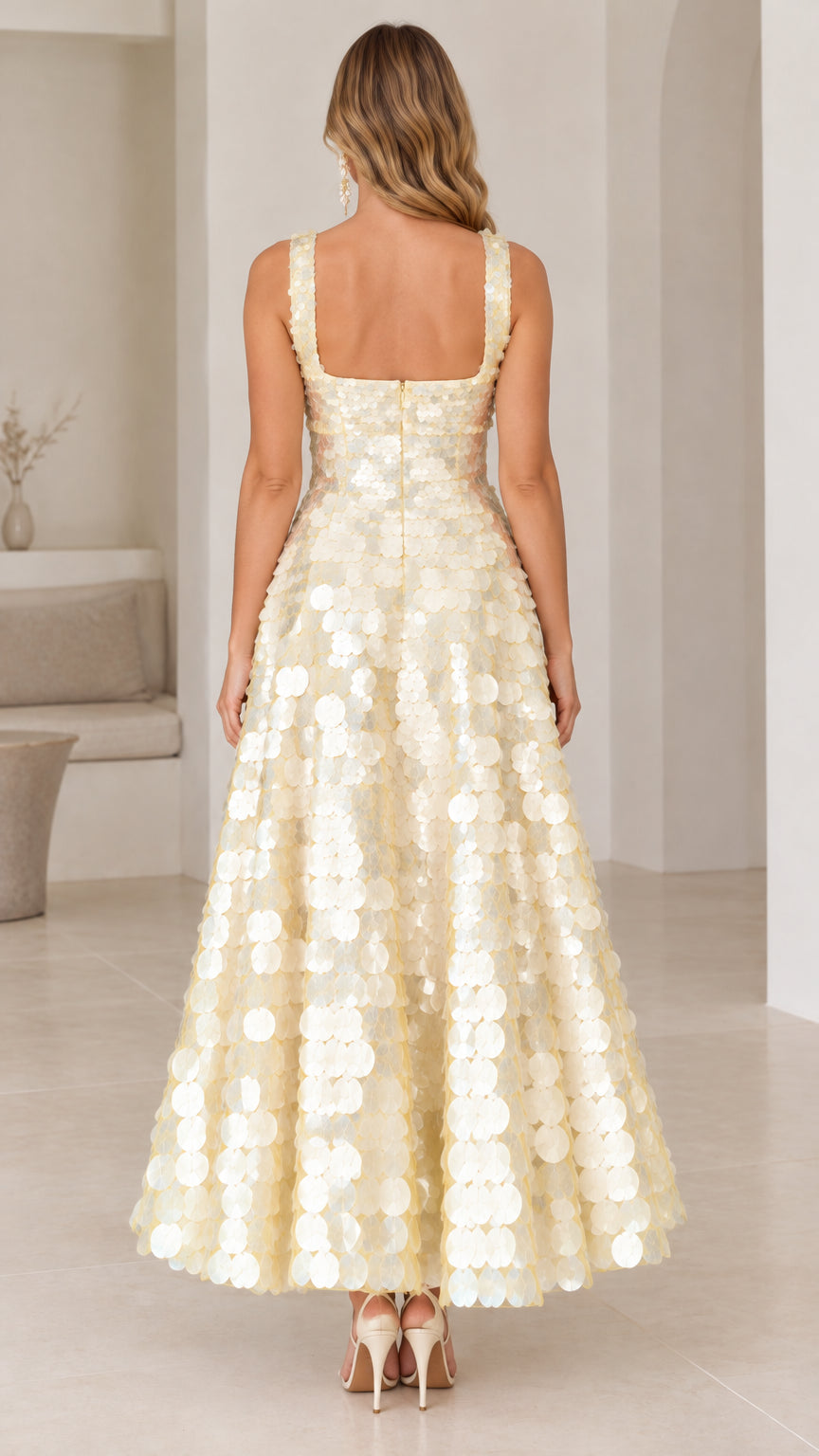 Back view of model showcasing the square back and flared skirt of the champagne sequin dress