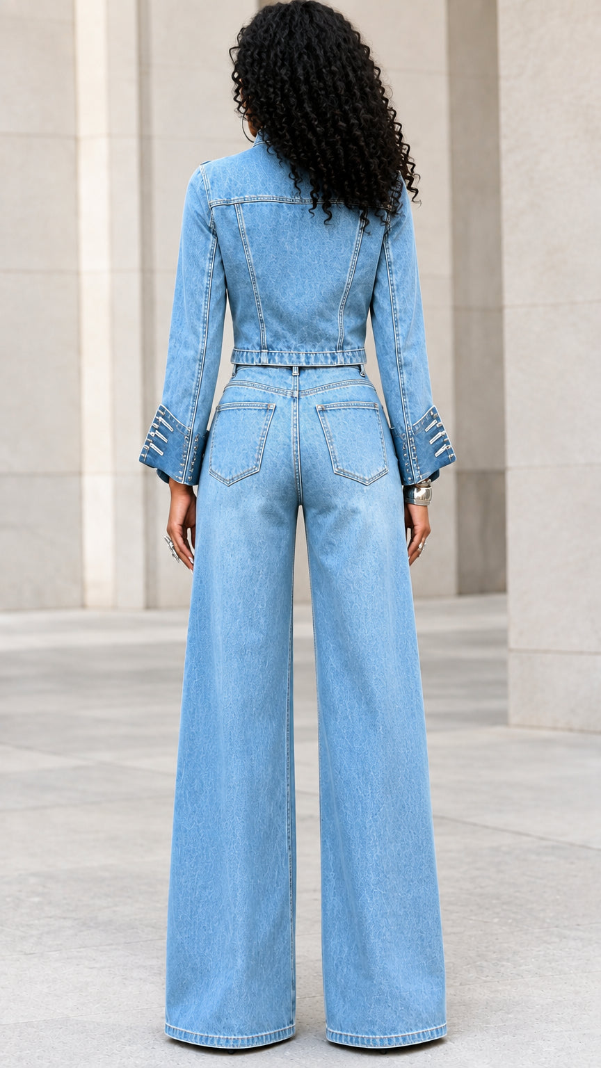 Back view of model wearing light blue military denim jacket and wide-leg jeans