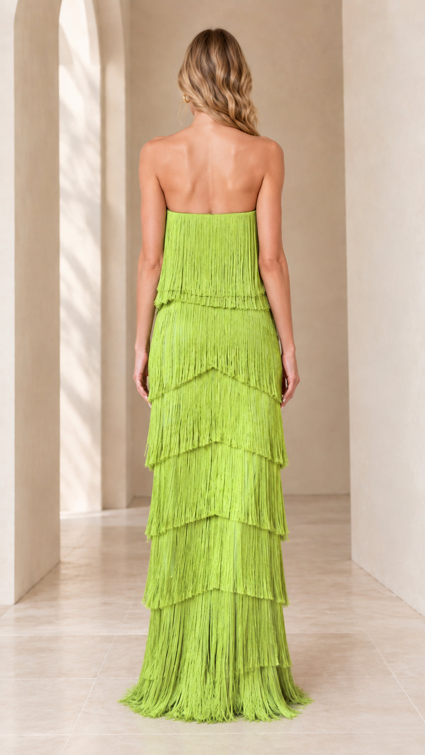 Back view of model in lime green strapless tiered fringe evening gown