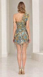 Back full-length view of woman wearing sky blue embellished one-shoulder mini dress with hanging fringe hem