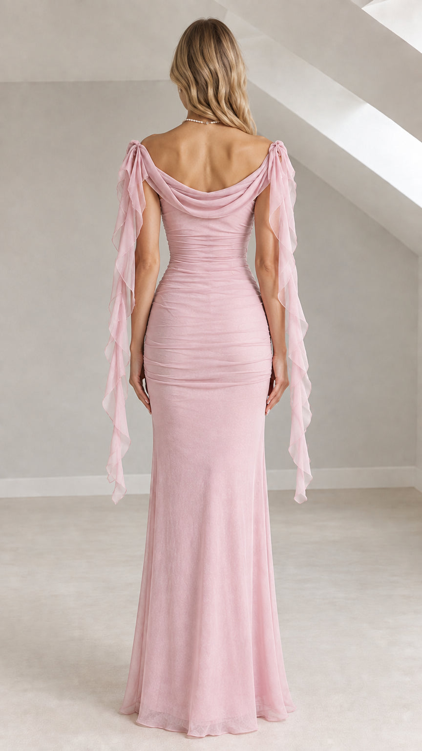 Back view of a woman wearing a dusty pink cowl-back off-the-shoulder ruched maxi evening gown