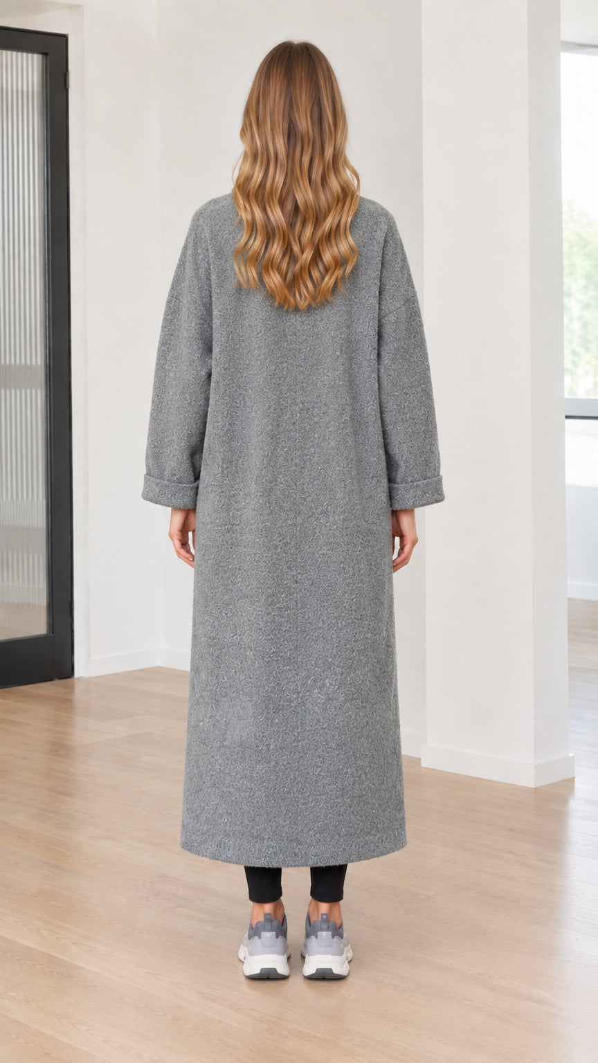 Back full-length view of model wearing grey long bouclé coat