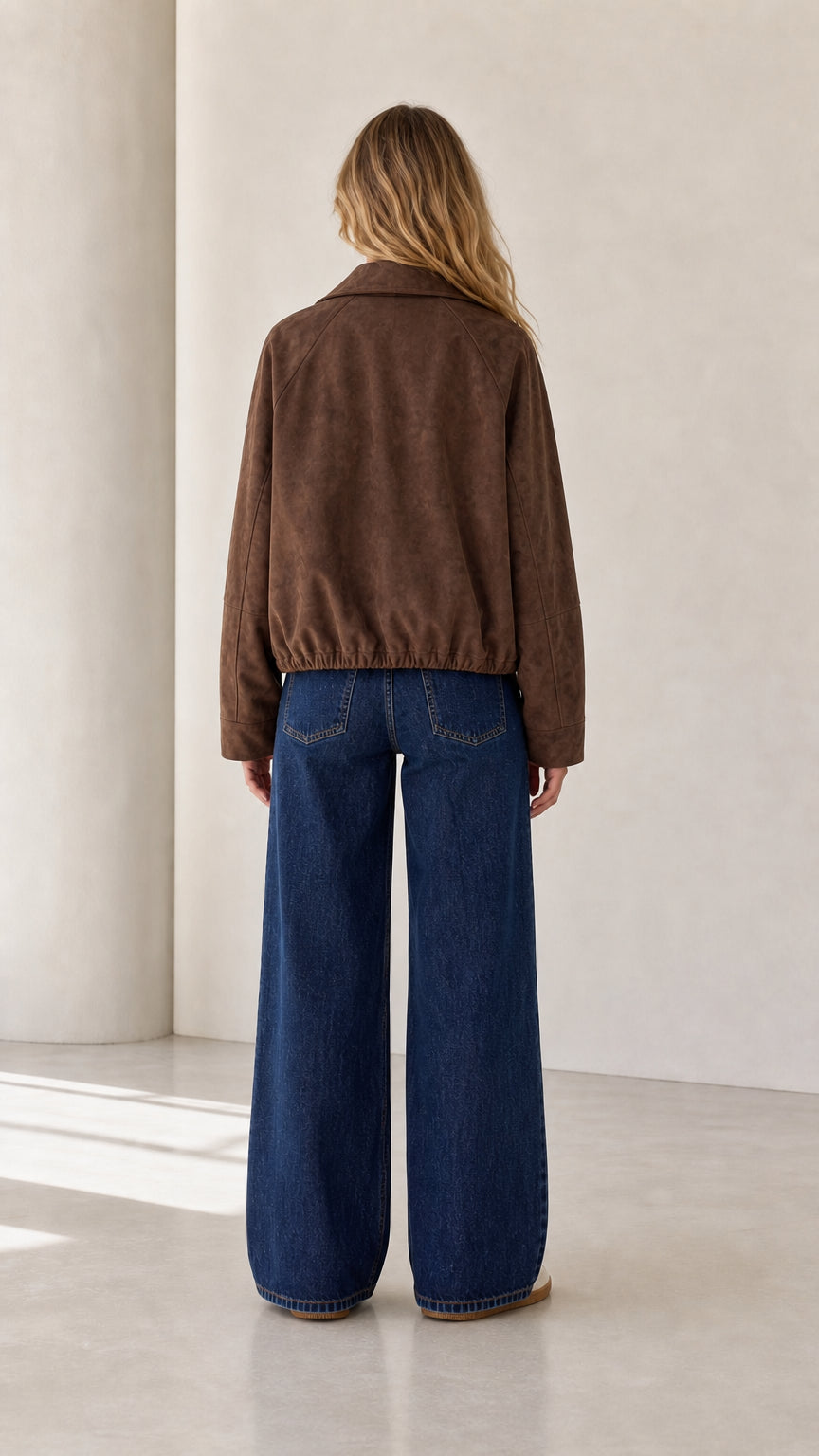 Back view of the brown cropped faux suede jacket with elasticized hem