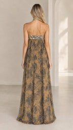 Back view of woman wearing strapless golden tan floral print maxi dress