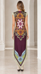 Back view of woman wearing plum floral print maxi dress featuring symmetrical print and pointed hemline