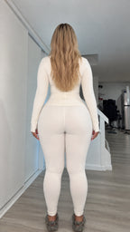 Back view of woman wearing cream zip jacket and matching fitted leggings