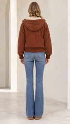 Back view of woman wearing brown hooded bomber jacket with ribbed hem