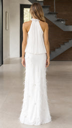 Back view of woman in white sleeveless halter pleated evening gown