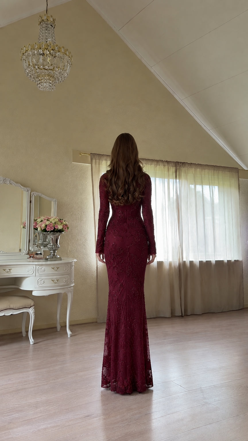 Back view of woman wearing burgundy floor-length embroidered evening gown