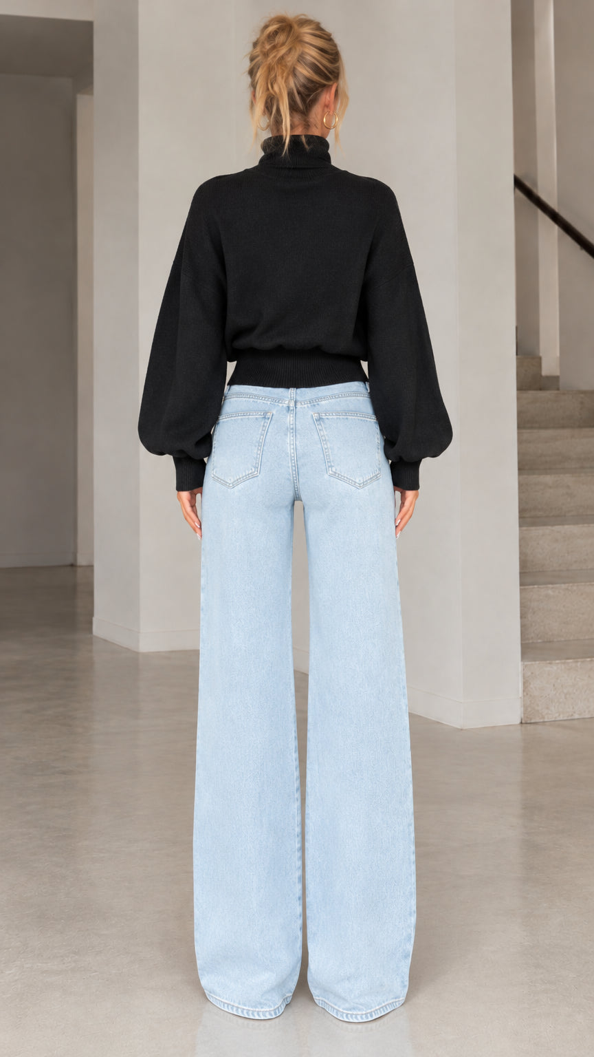 Back view of model wearing black high neck lantern sleeve sweater