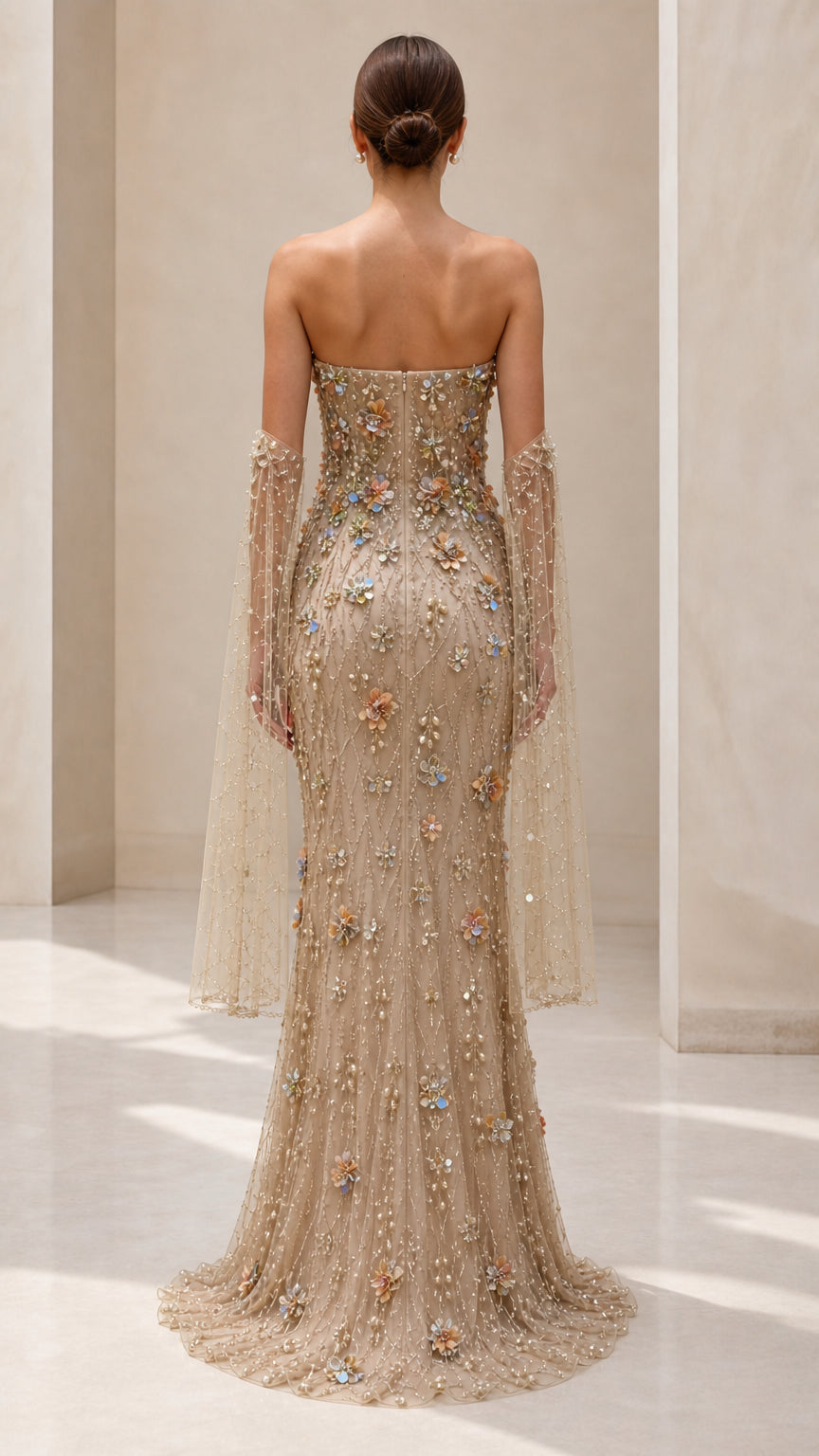 Back view of strapless champagne evening gown with draped sleeve accents