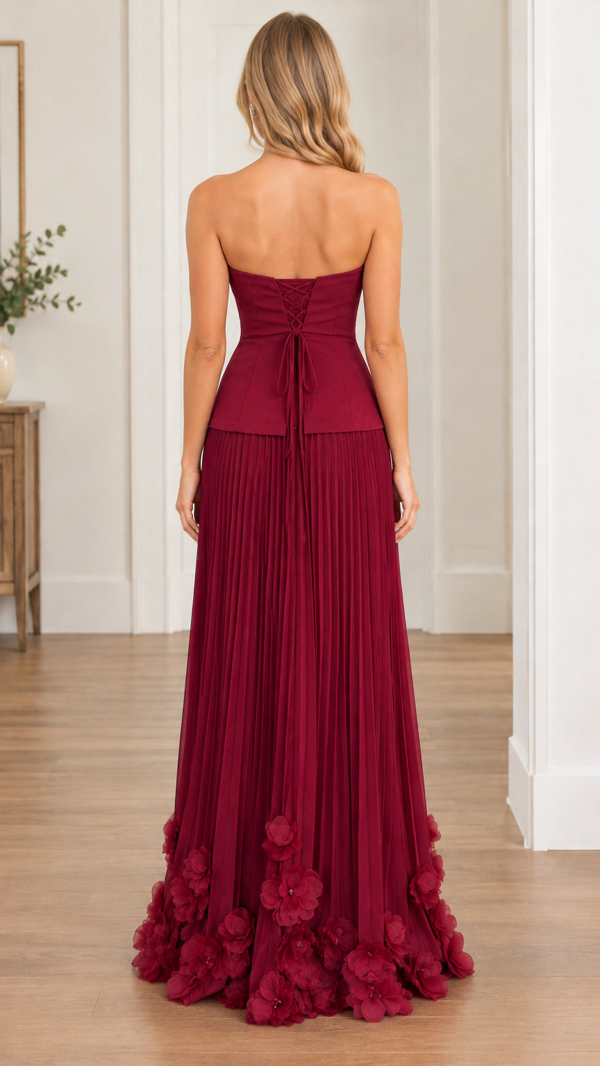 Back view showing lace-up corset detail and pleated skirt of burgundy evening dress