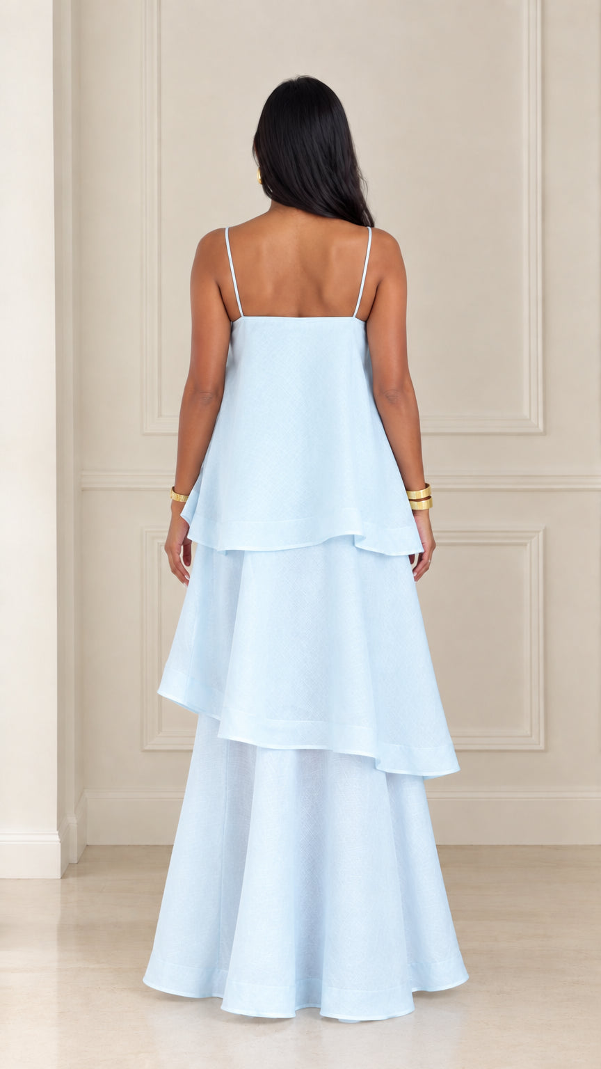 Back view of woman wearing light blue tiered spaghetti strap maxi dress