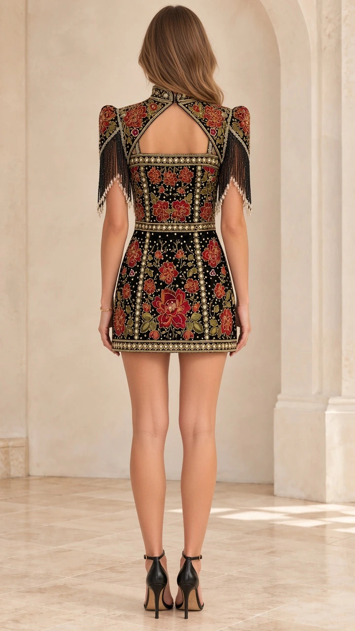 Back view of model showing cut-out back detail on black embroidered mini dress