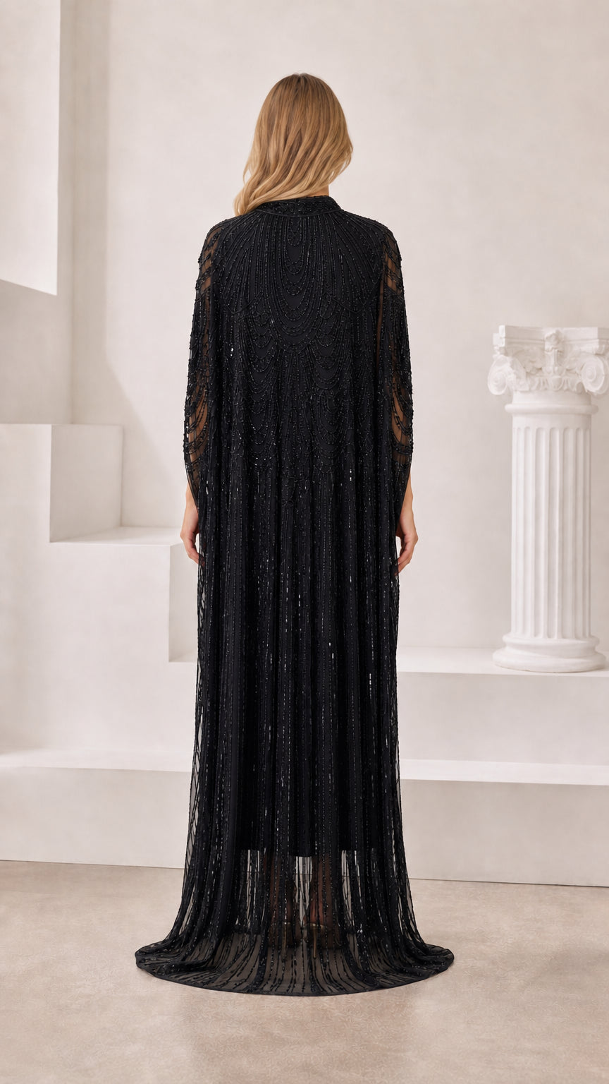 Back view of model in floor-length black sequin cape dress