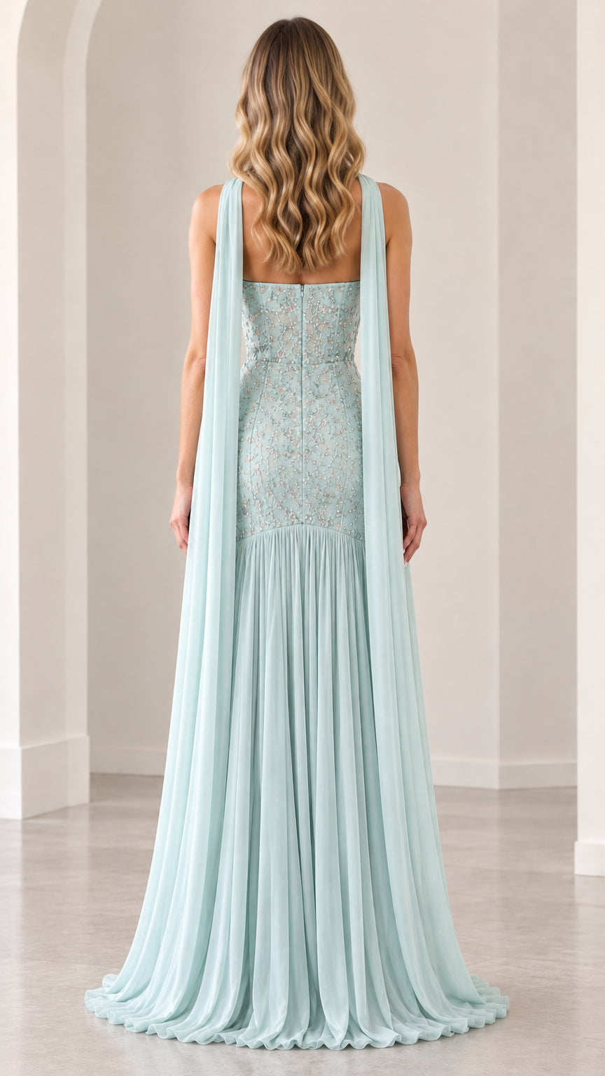 Back view of mint green strapless evening gown displaying trailing scarf cape and back pleating