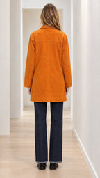 Back view of woman wearing cognac mid-length buttoned car coat