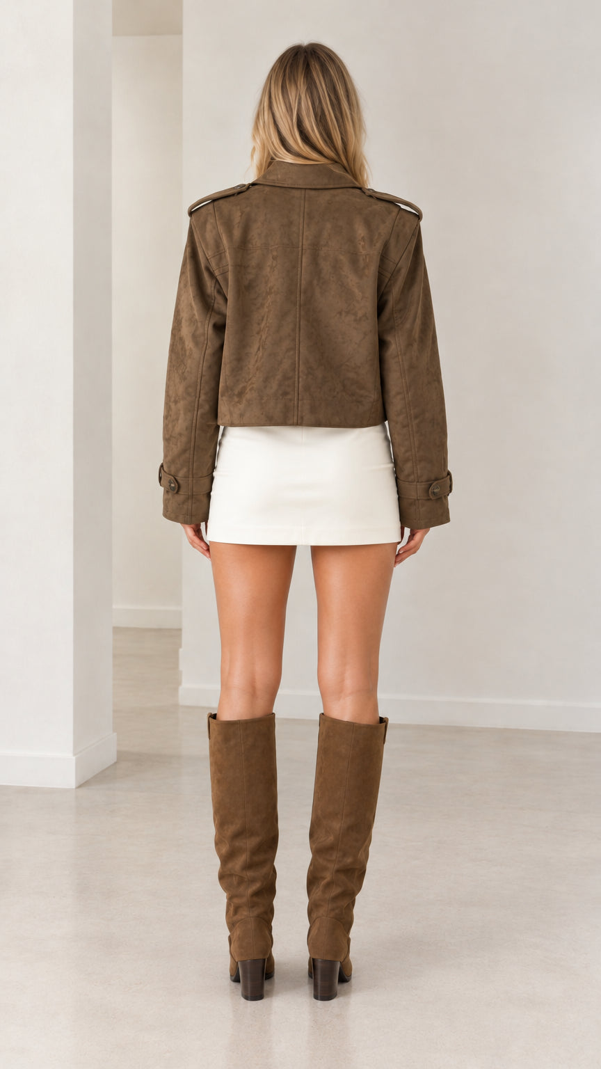 Back view of model wearing brown cropped faux suede jacket with clean tailored finish