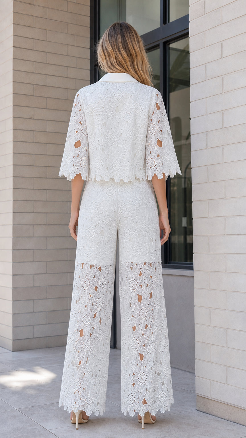 Back view of model in white collared lace top and wide-leg trousers