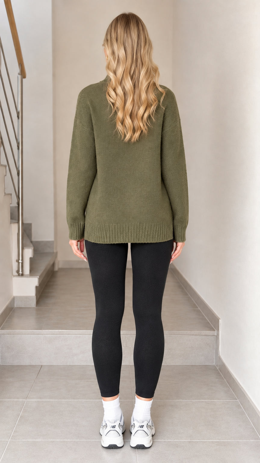 Back view of model wearing olive green mock neck knit sweater