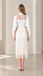 Back view of model showing sheer lace back and cape sleeves in white