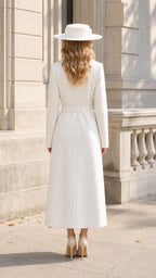 Back view of model wearing tailored full-length white wrap coat with tie belt