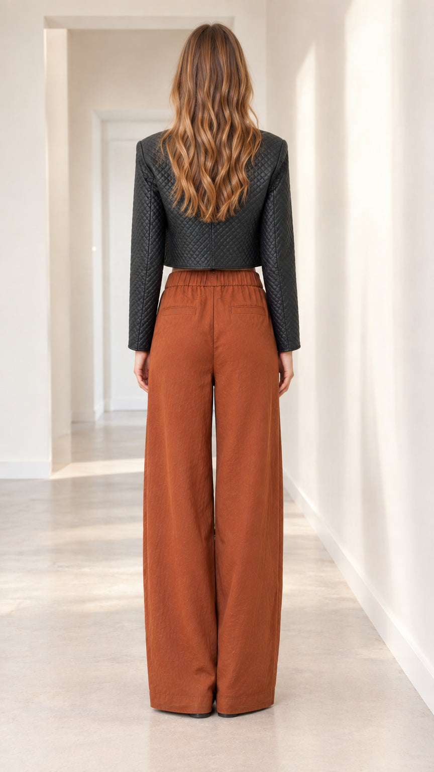 Back view of black cropped jacket and tailored high-waist trousers