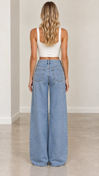 Back view of woman wearing light wash wide-leg denim jeans featuring classic back pockets
