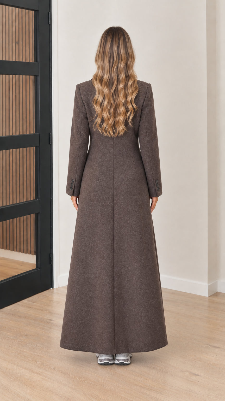 Back view of model wearing the tailored brown floor-length overcoat