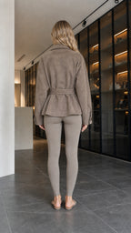 Back view of model showing belted waist and hem of taupe faux suede jacket