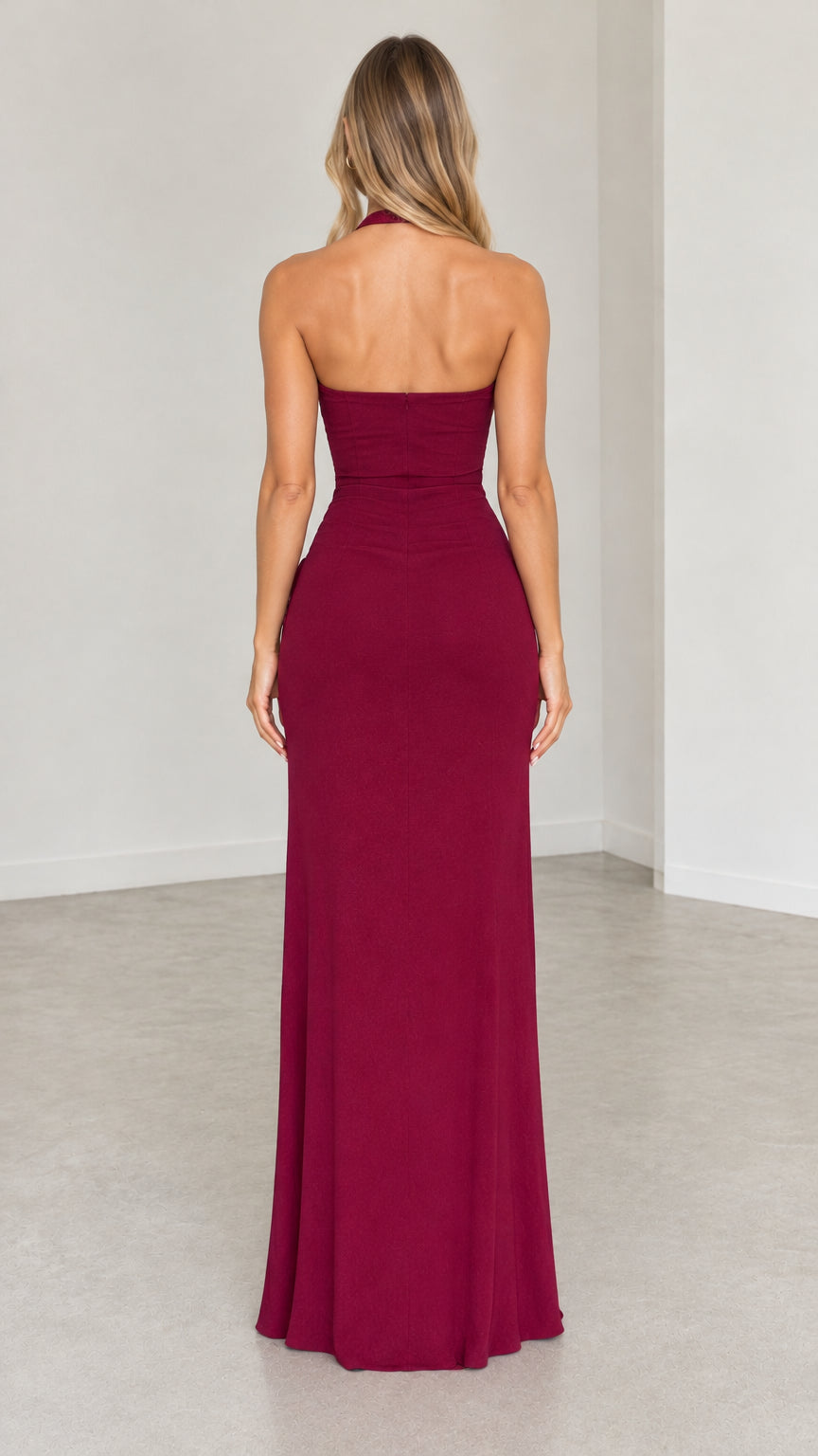 Back view of model wearing burgundy open-back halter evening maxi dress