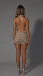 Back view of model in Champagne open back beaded fringe mini dress