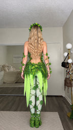 Back view of model in green leaf fantasy fairy costume showing open back and draped tassel skirt