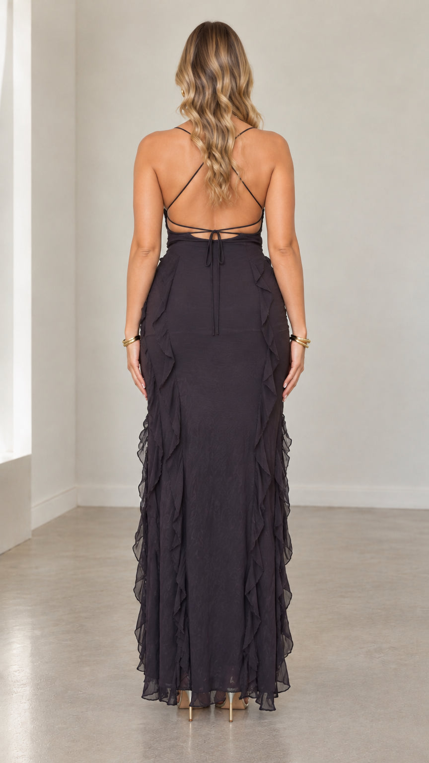 Back view of black maxi dress highlighting crisscross lace-up open back