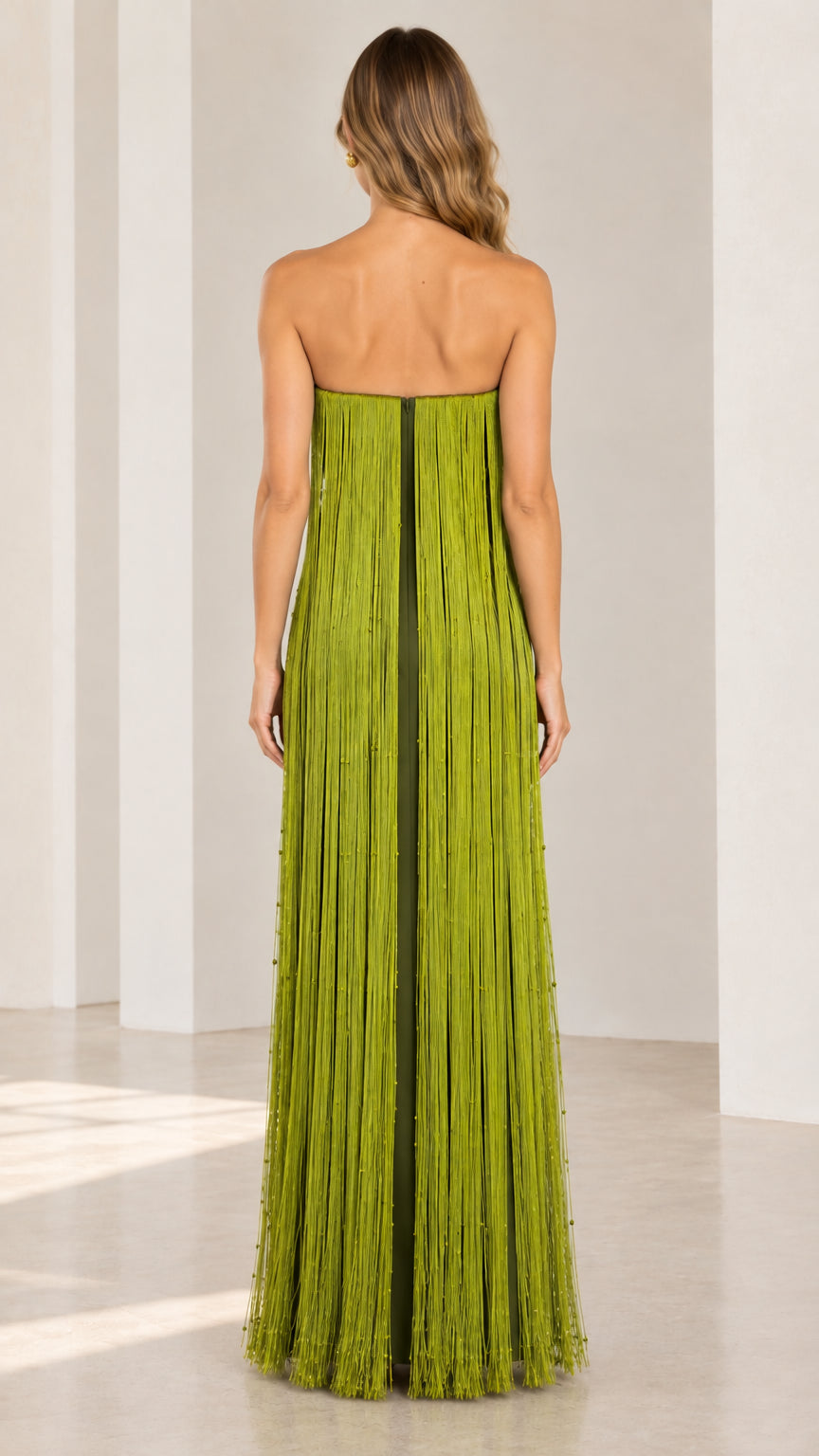 Back view of model in floor-length strapless olive green fringe dress