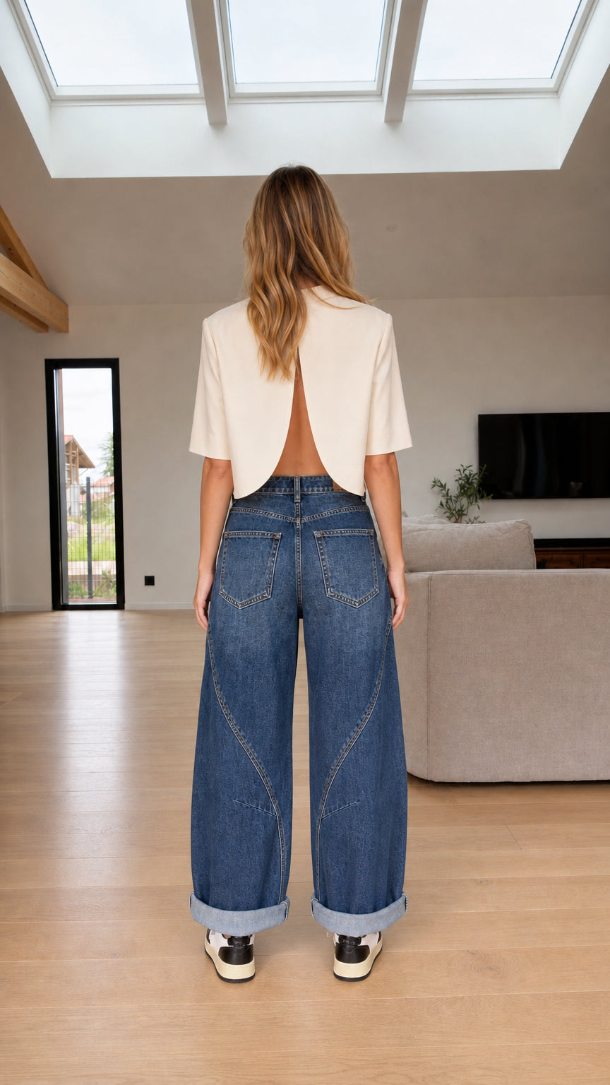 Back view of model wearing medium blue wide-leg jeans with diagonal seam lines